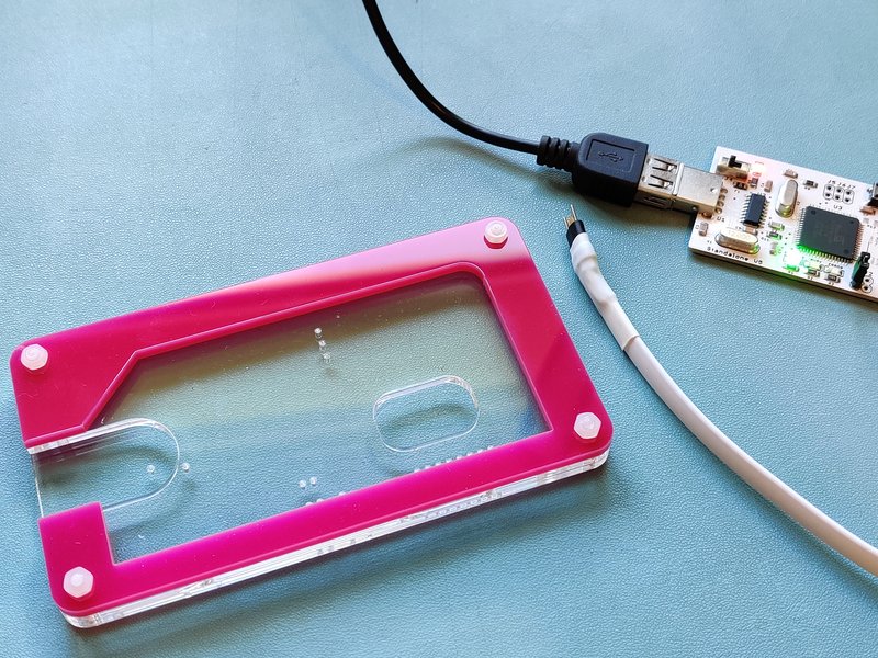 Laser cut perspex jig with an RC2014 module shaped cut out along with finger holes to remove the PCB and a hole below the programming pads for the locator pins to go